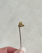 gold fox stick pin brooch with red ruby eye held above white background
