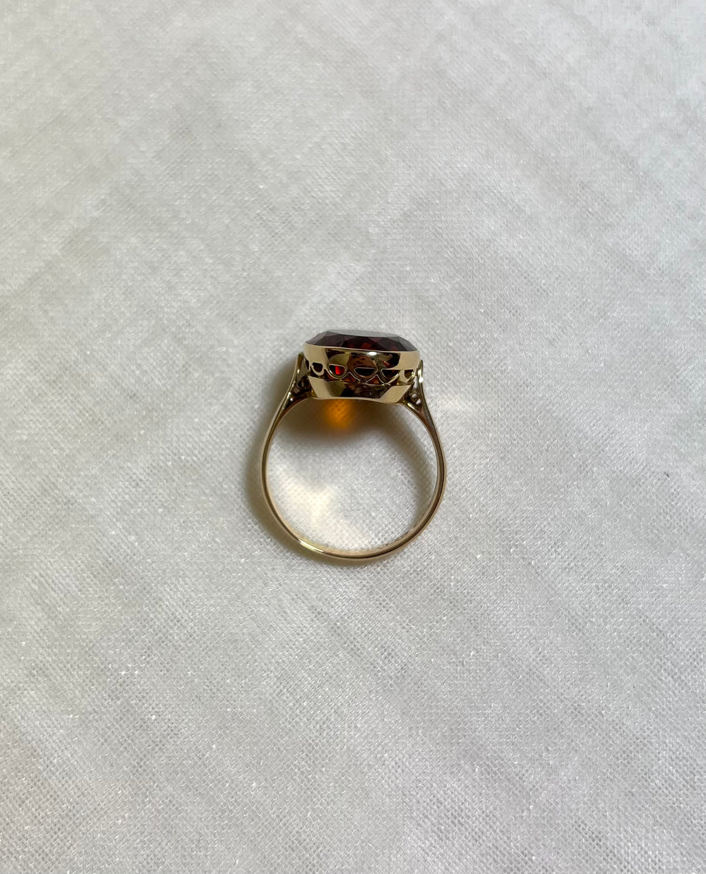 above view of gold ring on white fabric background