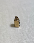 gold charm on white fabric background