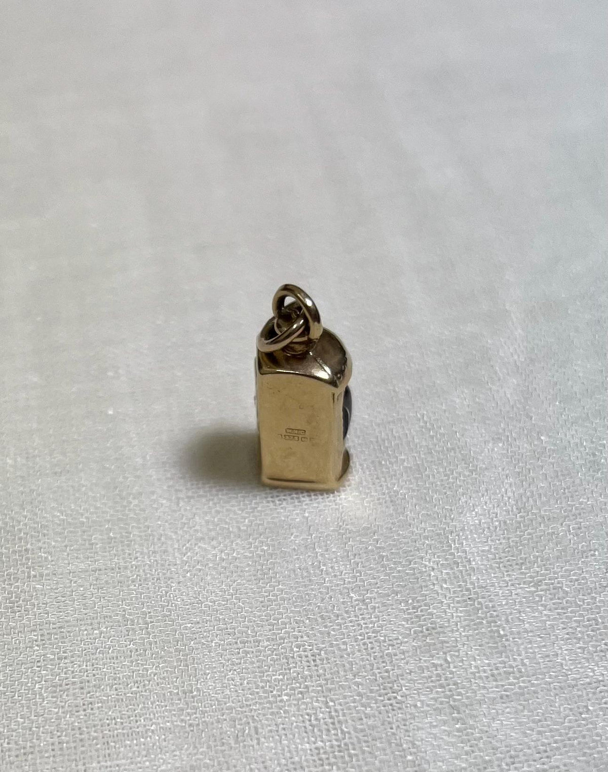 gold charm on white fabric background
