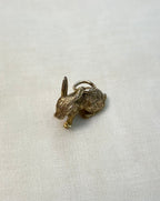 gold rabbit charm on white fabric background
