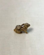 gold rabbit charm on white fabric background