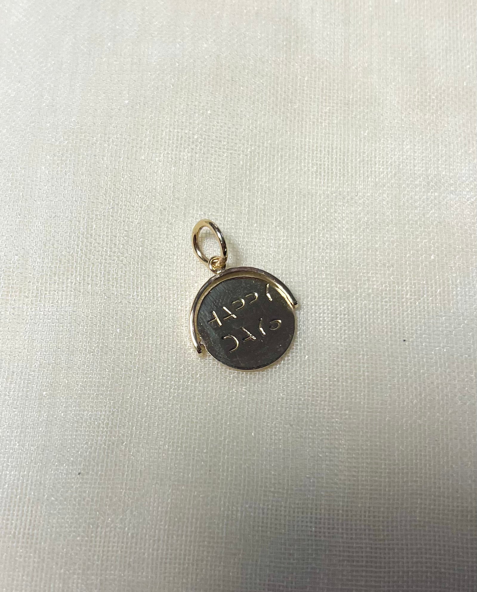 gold round charm with 'happy days' message on cream linen background 