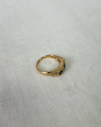 Gold ring with a blue gemstone on a light fabric background