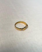 Gold ring with small diamonds on a light fabric background