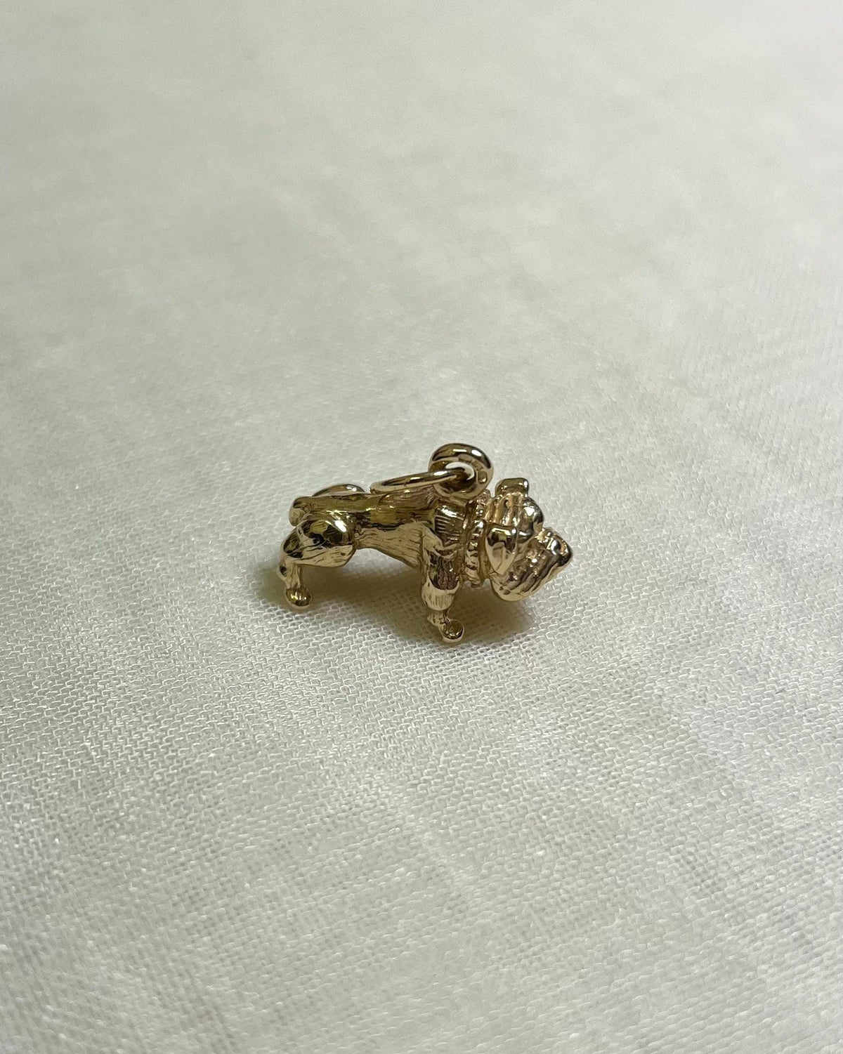 Gold bulldog charm on a light fabric background