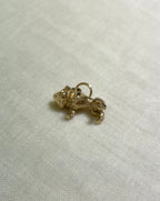 gold dog charm on light fabric background 