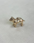 Gold dog charm on white fabric background