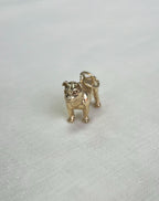 Gold bulldog charm on a white fabric  background
