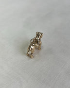 Gold dog-shaped charm on a white fabric  background