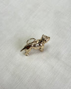 gold dog charm on white fabric background