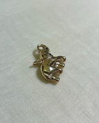large gold elephant charm on white fabric background