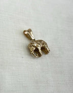 Gold elephant pendant on a light fabric background