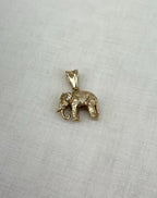 Gold elephant pendant on a light fabric background