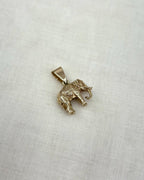 Gold elephant pendant on a light fabric background