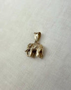 Gold elephant pendant on a light fabric background