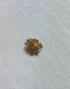 gold hedgehog charm on cream fabric background 