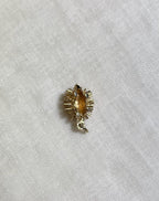 gold hedgehog charm on cream fabric background 