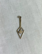 back view of gold pendant on white fabric background 