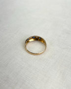 back view of gold ring resting on white fabric background 
