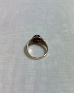 back view of gold ring on white fabric background 