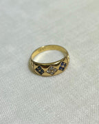 Gold ring with embedded stones on a light fabric background