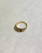 Gold ring with blue stones on a white fabric background