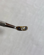 Gold ring with blue and white gemstones on a white background