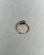 back view of gold ring resting on white fabric background