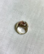 three tone gold ring from above view, on a white fabric background 