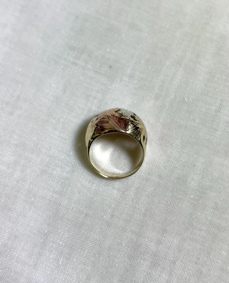 three tone gold ring from above view, on a white fabric background 