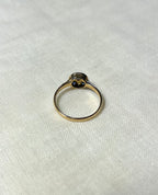 back view of gold ring, on white fabric background