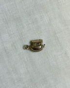 gold noahs ark boat charm on light fabric background 