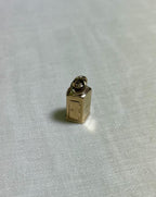 Small gold charm on a white fabric background