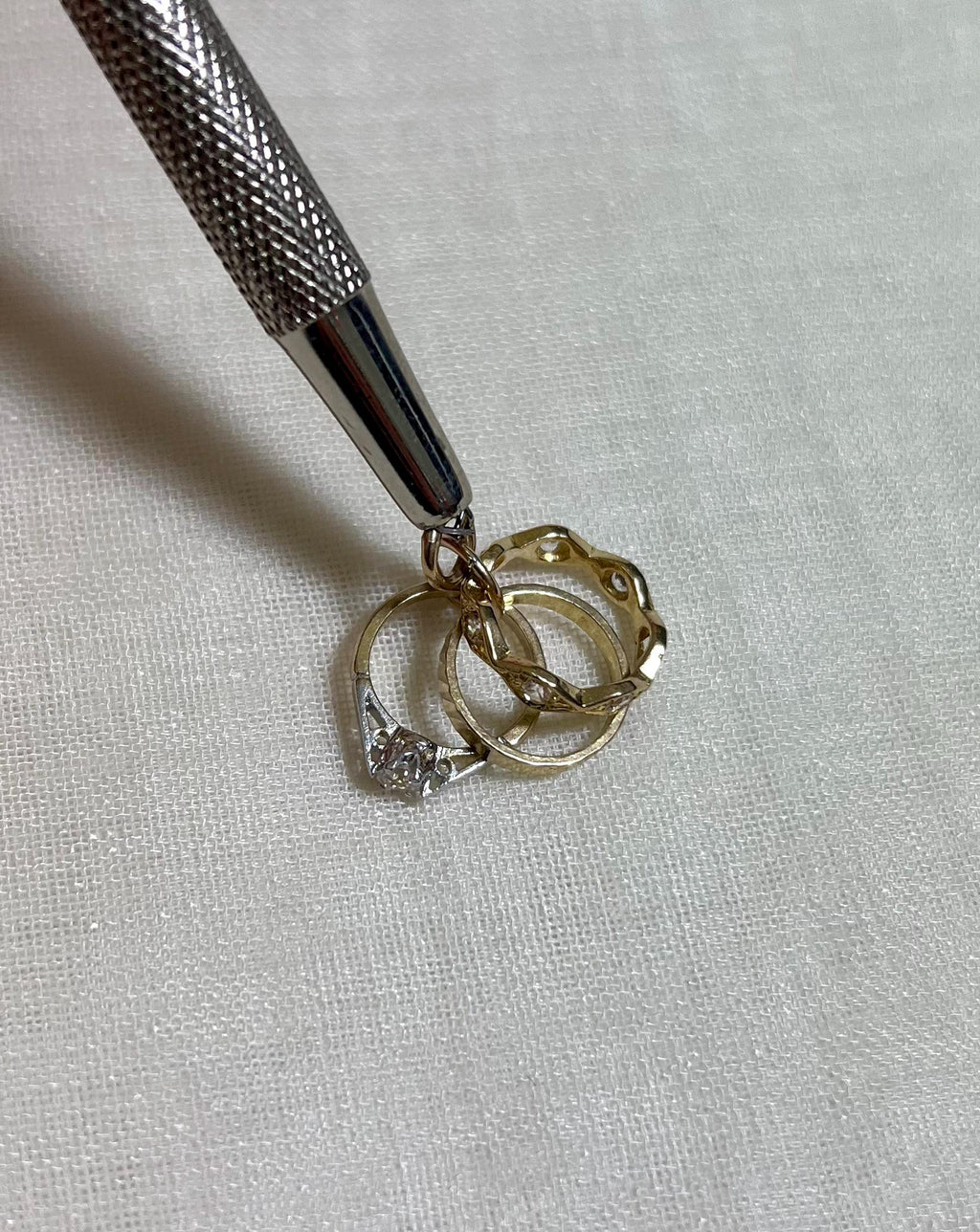 gold ring charm on white fabric background 