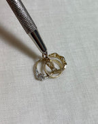 gold ring charm on white fabric background 