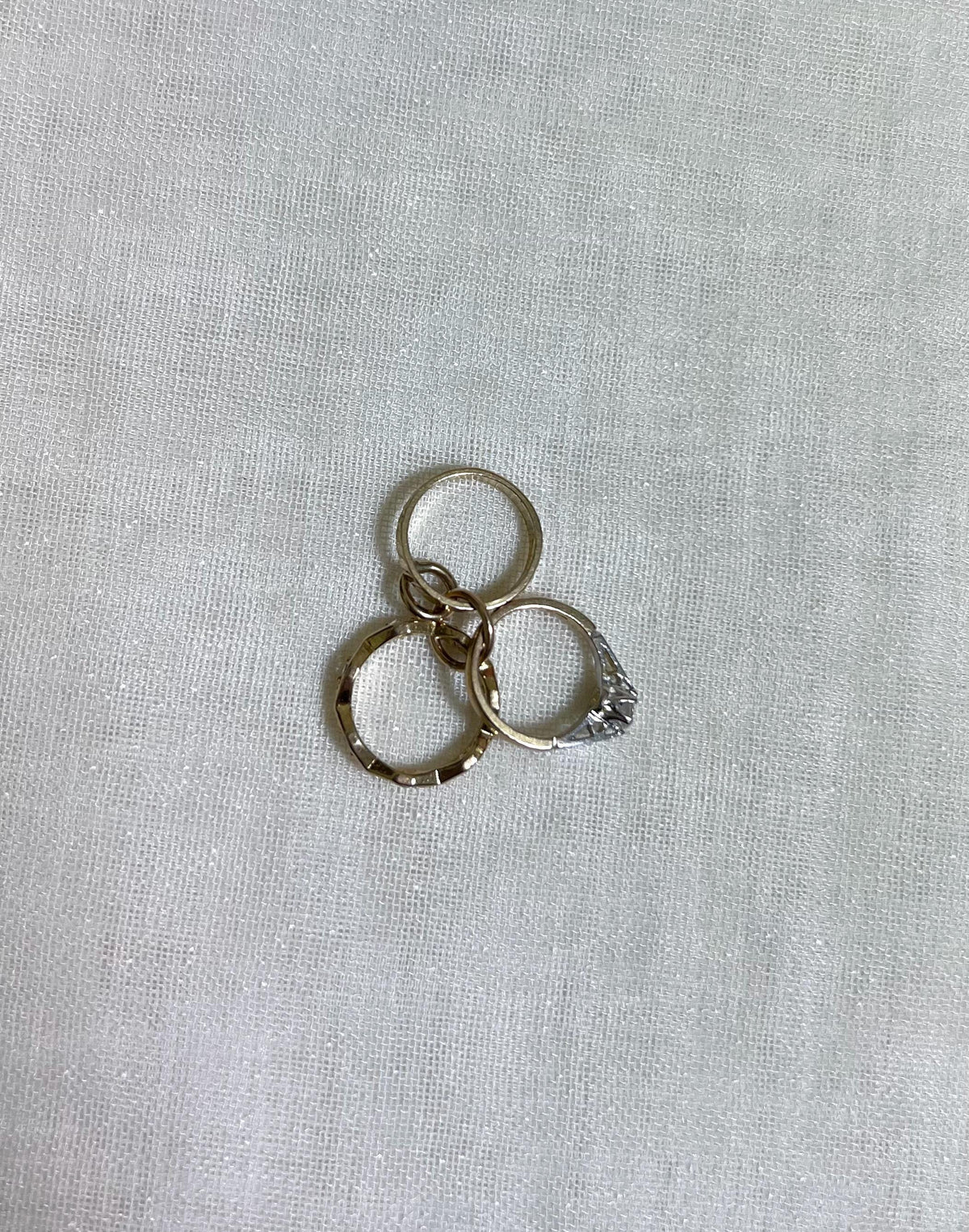 3 gold ring on white fabric background