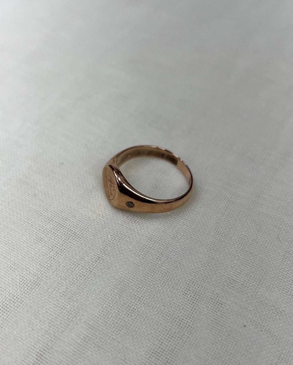 rose gold ring on white fabric background