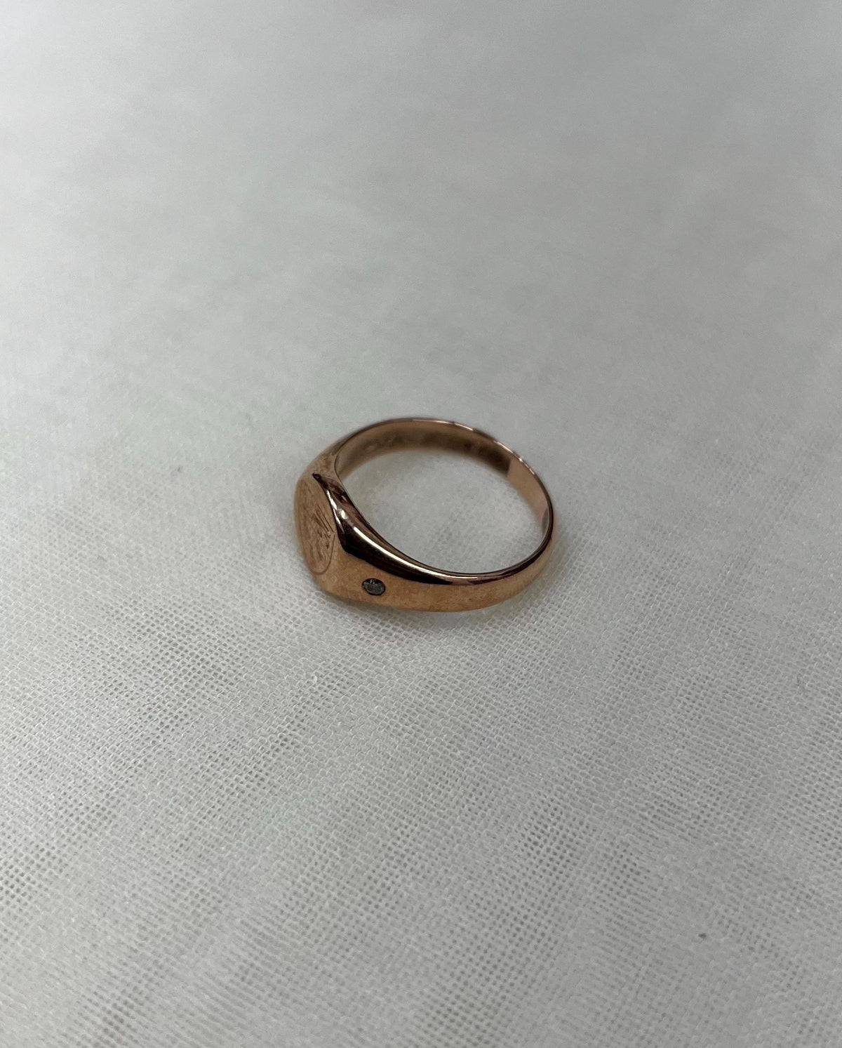 rose gold ring on white fabric background