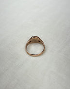 back view of rose gold ring on white fabric background 