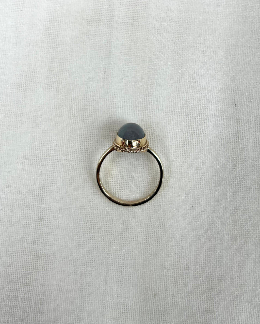 top view of gold ring on white fabric background 