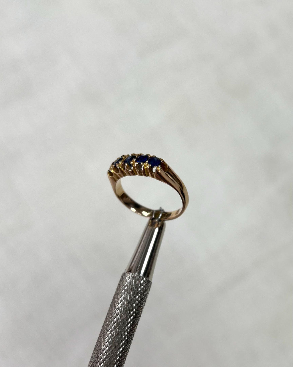 Gold ring with blue gemstone on a white background