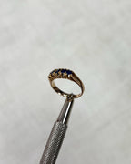 Gold ring with blue gemstone on a white background