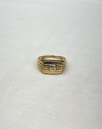 gold signet ring with diamond centre on white fabric background 