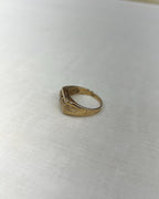 side view of Gold ring on a white fabric background