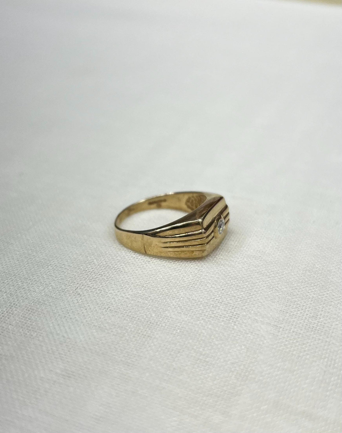 Gold ring with a diamond on a white background