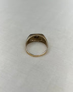 back view of gold ring on white fabric background 