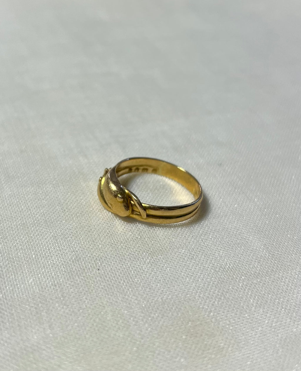 gold snake head ring with double band, resting on white fabric background