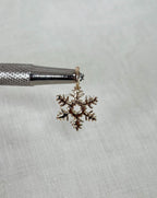 Gold snowflake pendant on a textured white background