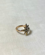 gold star ring set with diamonds on white fabric background 